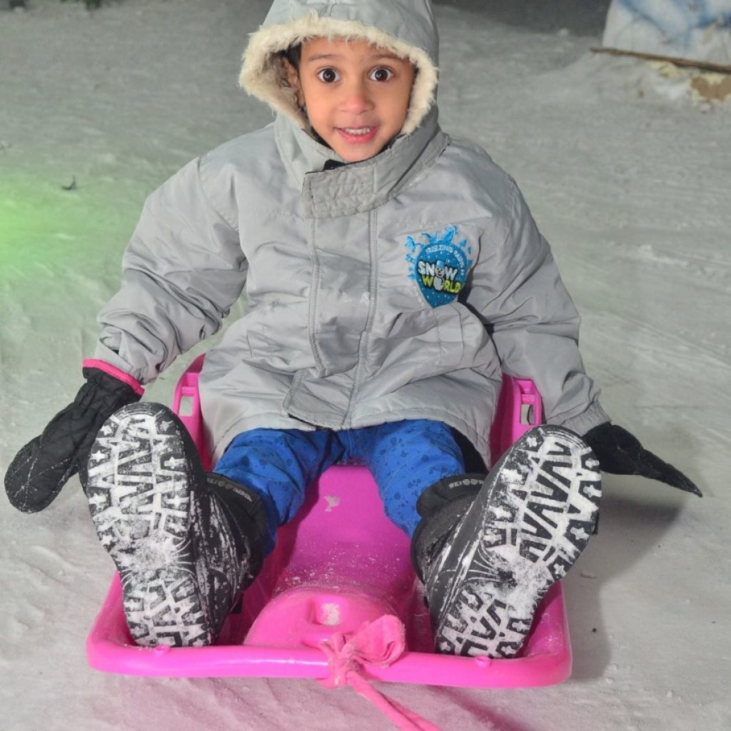speeding through the snow with a sled and a smile